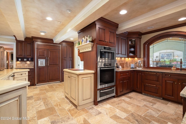 kitchen with paneled built in fridge, a sink, stone tile flooring, crown molding, and a warming drawer