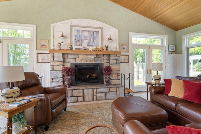 living area with a stone fireplace, lofted ceiling, and wood ceiling