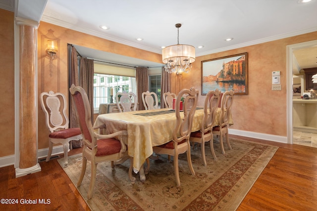 dining space featuring a chandelier, ornamental molding, baseboards, and wood finished floors