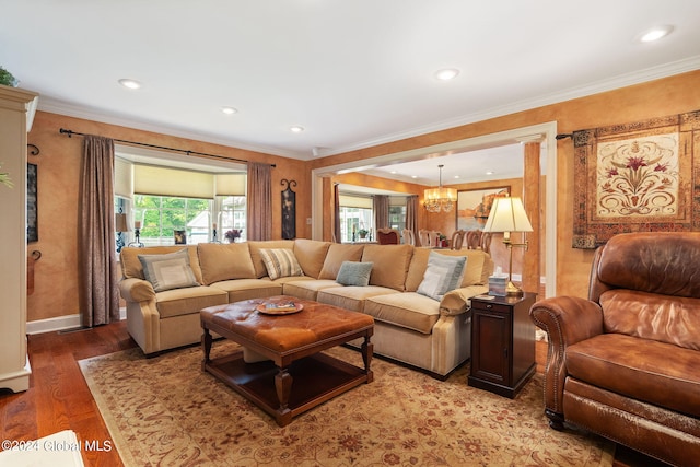 living room featuring a chandelier, ornamental molding, and wood finished floors