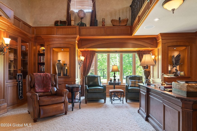 living room featuring built in features, light carpet, and a high ceiling