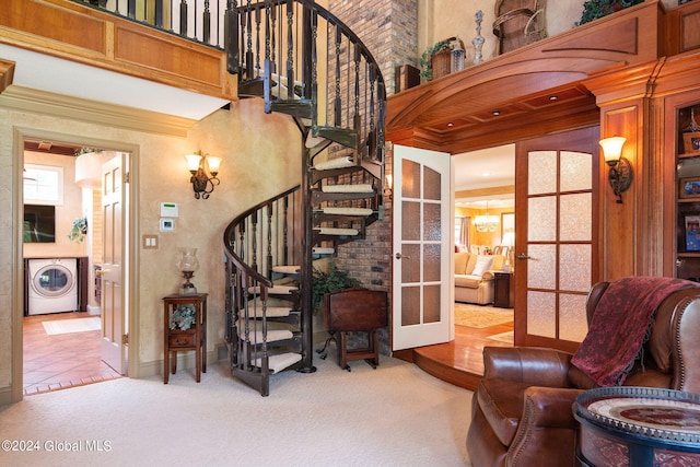 staircase with carpet flooring, a high ceiling, washer / clothes dryer, and french doors