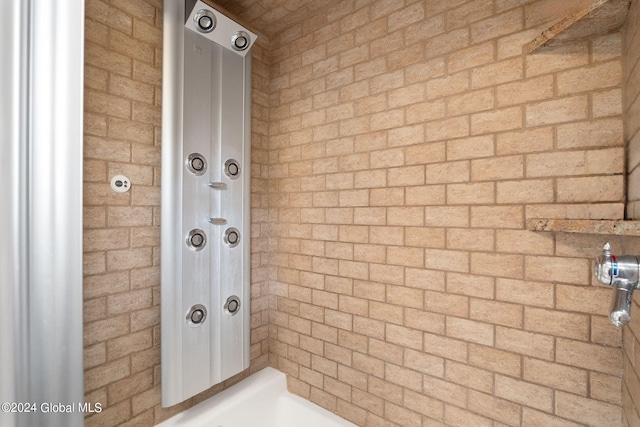 bathroom featuring brick wall