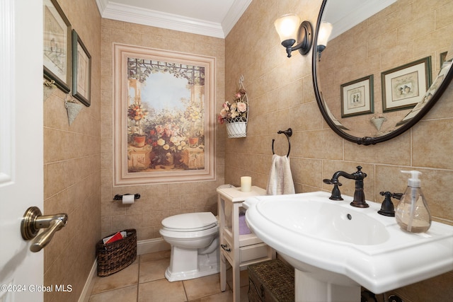 half bathroom with ornamental molding, a sink, tile walls, toilet, and tile patterned floors