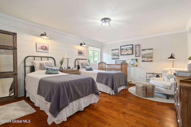 bedroom with crown molding and wood finished floors