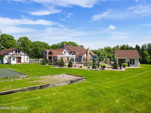 back of house with a playground, a lawn, and fence