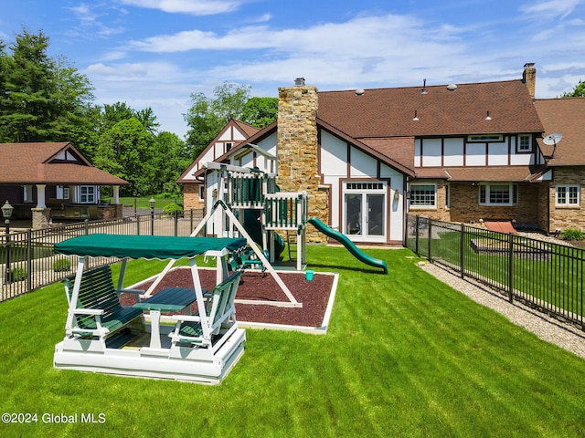 community playground featuring a yard and fence