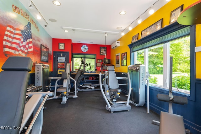 workout area with rail lighting and a wall unit AC