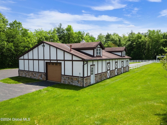 view of front facade featuring stone siding, a garage, a front yard, and fence