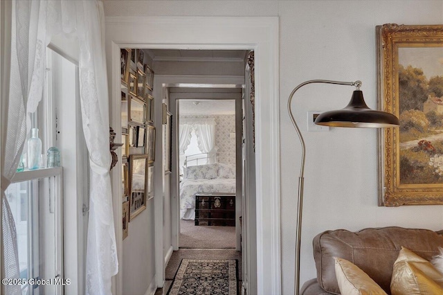 corridor with wallpapered walls, carpet, and ornamental molding