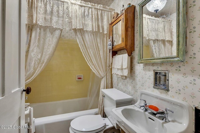 full bathroom with toilet, wallpapered walls, and shower / bath combo