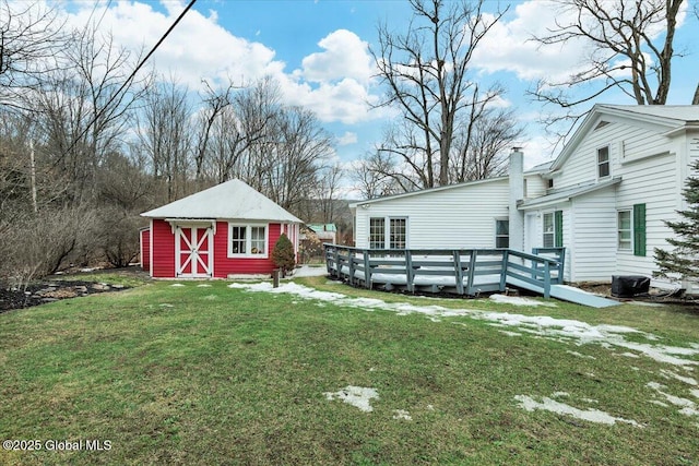 view of yard featuring a storage shed, an outbuilding, a deck, and cooling unit