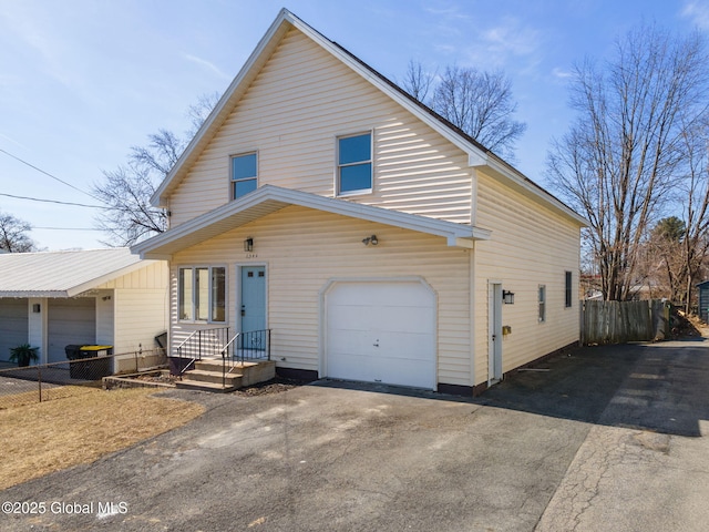 view of front of house with fence, a garage, and driveway