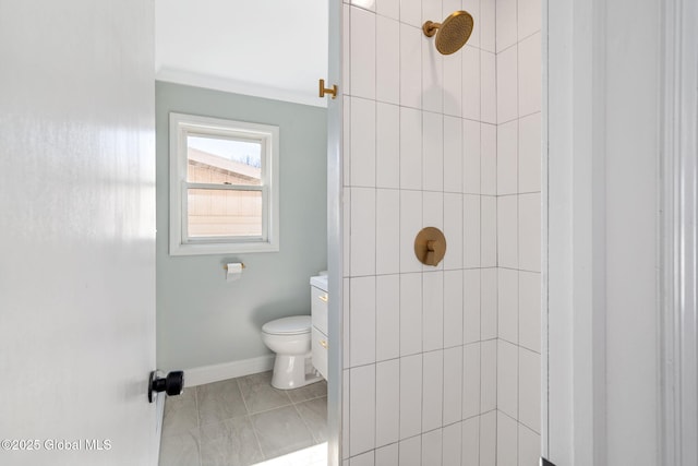 bathroom featuring tile patterned flooring, toilet, tiled shower, and baseboards