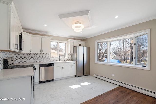 kitchen featuring a baseboard radiator, decorative backsplash, appliances with stainless steel finishes, crown molding, and marble finish floor