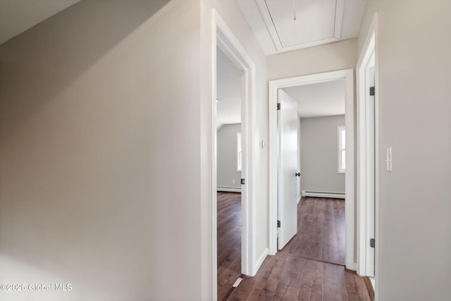 hallway with attic access, wood finished floors, and a baseboard radiator