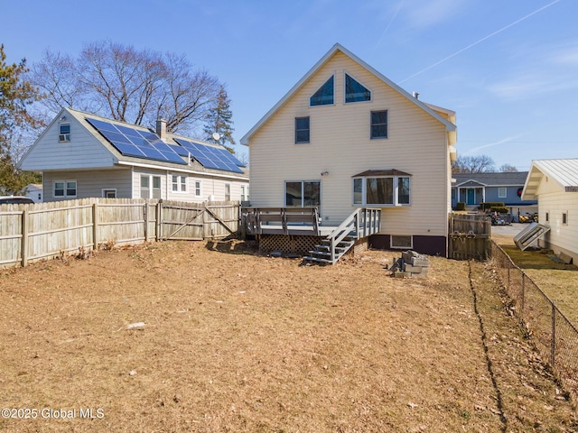 rear view of house with a deck and a fenced backyard