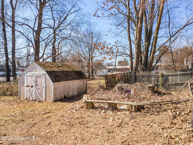 view of yard with a storage shed, an outdoor structure, and fence