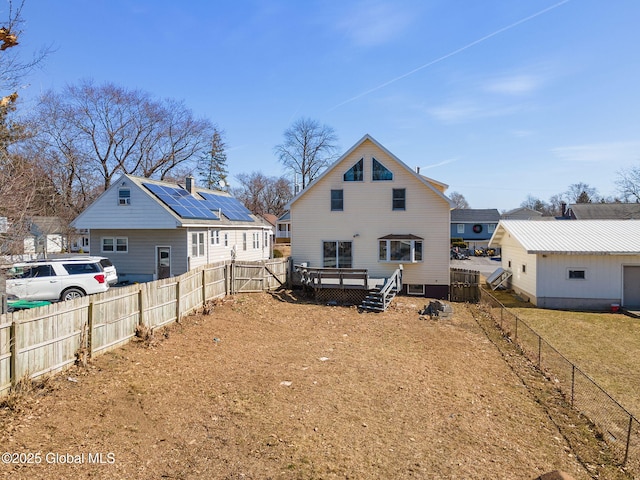 back of property featuring a deck and a fenced backyard