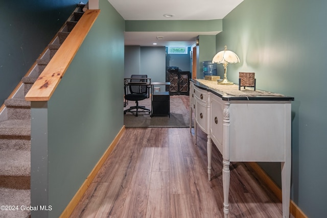 hallway featuring stairway, baseboards, and wood finished floors