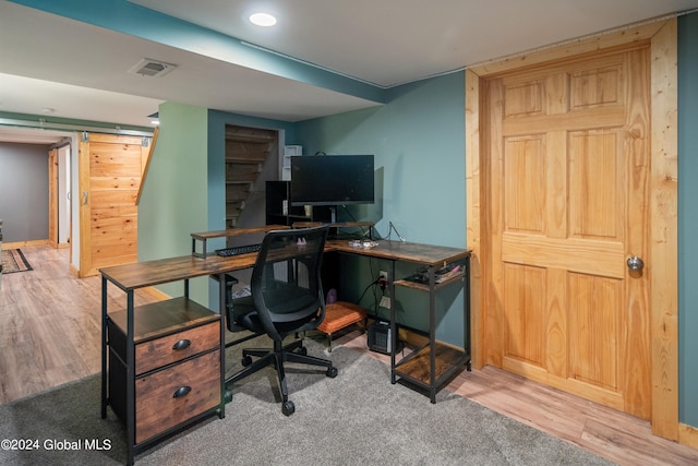 office space featuring wood finished floors, visible vents, and baseboards