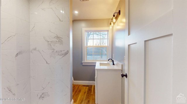 full bathroom featuring vanity, wood finished floors, and baseboards