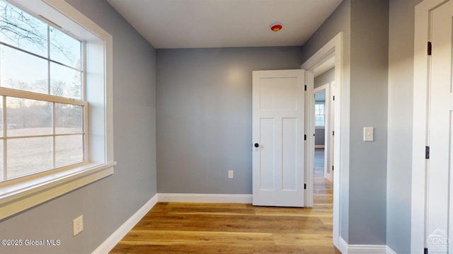 empty room with light wood-style floors and baseboards