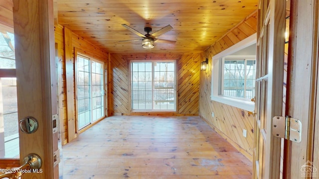 unfurnished sunroom with wood ceiling and ceiling fan