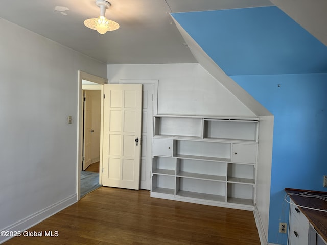 unfurnished bedroom with wood finished floors, baseboards, and a closet