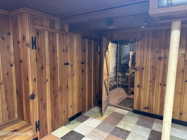 corridor with tile patterned floors and wood walls