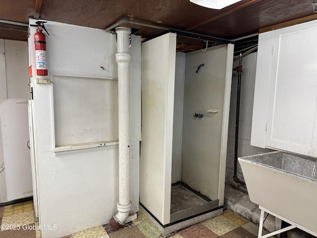 full bath with a shower stall, tile patterned floors, and a sink