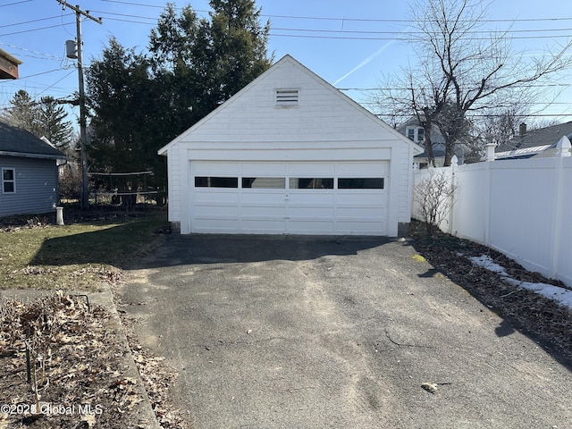 detached garage featuring fence