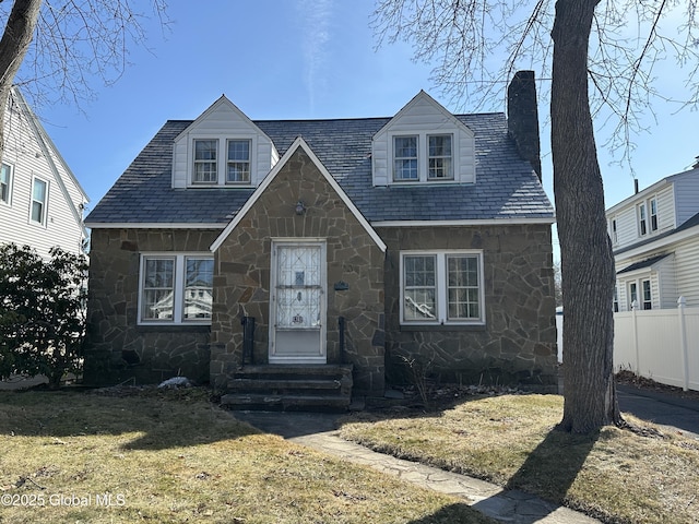 view of front of house with entry steps, fence, stone siding, and a chimney