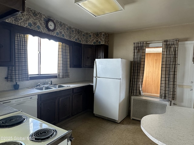 kitchen featuring radiator heating unit, white appliances, light countertops, and a sink