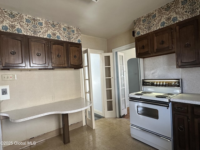 kitchen featuring dark brown cabinetry, electric range, arched walkways, and light countertops