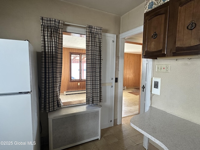 kitchen with baseboard heating, dark brown cabinets, light countertops, and freestanding refrigerator