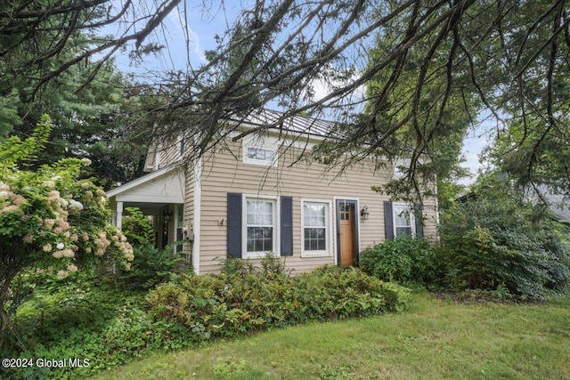 colonial home featuring a front lawn