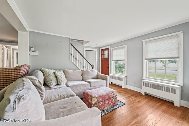 living area featuring stairs, radiator, baseboards, and wood-type flooring