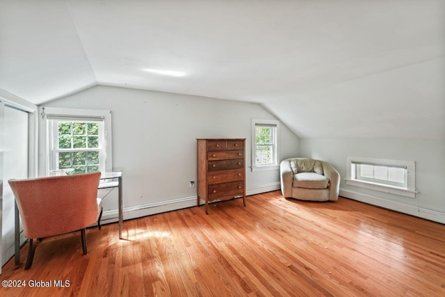 unfurnished room with baseboards, light wood-style floors, and vaulted ceiling