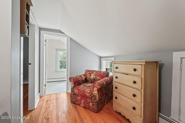 sitting room with light wood finished floors, baseboard heating, and lofted ceiling