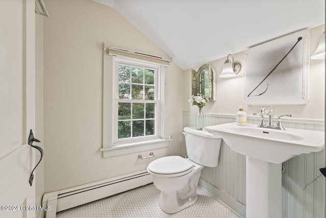 bathroom featuring tile patterned flooring, a baseboard heating unit, a wainscoted wall, toilet, and lofted ceiling