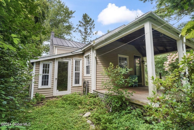 rear view of house featuring covered porch, metal roof, and a standing seam roof