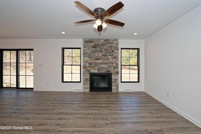 unfurnished living room with visible vents, baseboards, dark wood-style flooring, and a ceiling fan