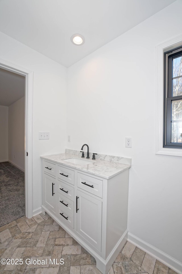 bathroom featuring recessed lighting, stone finish flooring, baseboards, and vanity