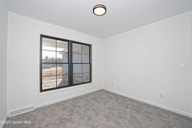 spare room featuring visible vents, baseboards, and carpet