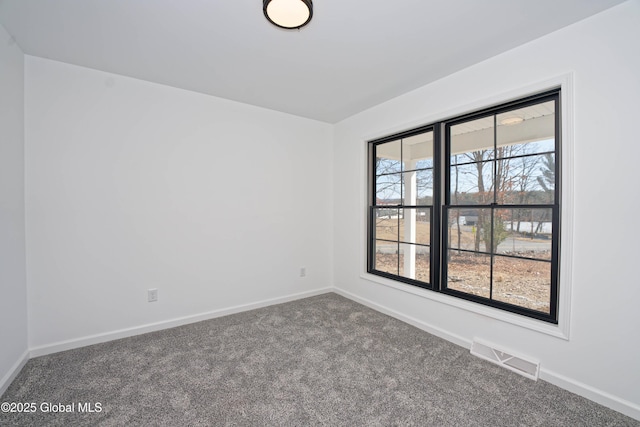 spare room with visible vents, baseboards, and carpet flooring