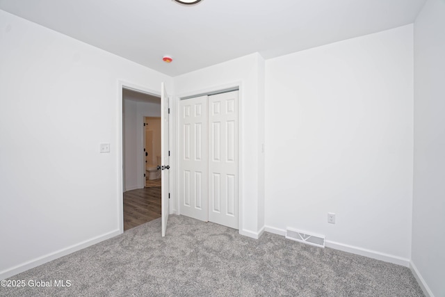 unfurnished bedroom with visible vents, baseboards, carpet, and a closet