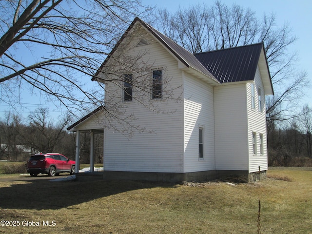 view of property exterior with metal roof and a yard