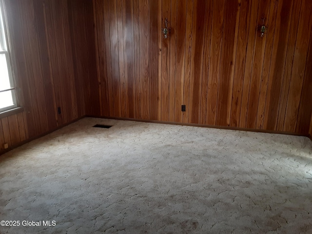 unfurnished room featuring visible vents and wood walls
