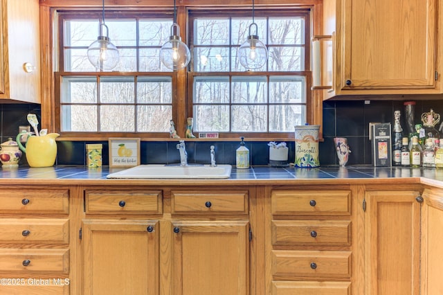 kitchen featuring a sink, decorative light fixtures, and tasteful backsplash